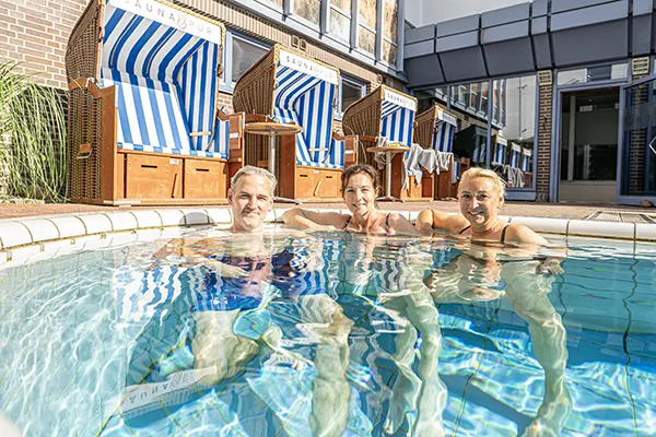 Gäste genießen das Außenbecken im Saunagarten von SAUNA PUR