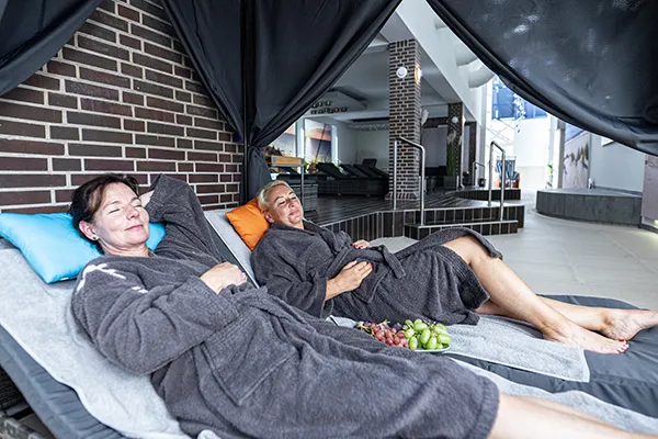 Zwei Gäste entspannen im gemütlichen Ruheraum von SAUNA PUR